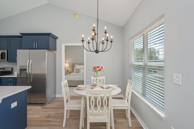 dining area with lofted ceiling, a notable chandelier, light wood-style floors, and baseboards