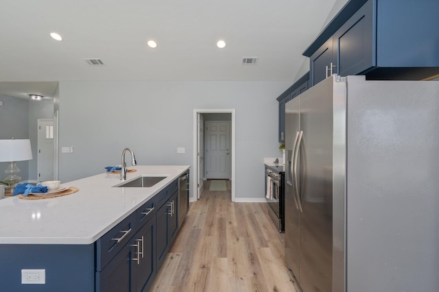 kitchen with visible vents, a sink, light countertops, appliances with stainless steel finishes, and light wood-type flooring