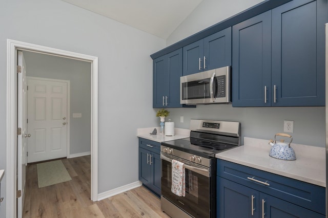 kitchen with blue cabinets, stainless steel appliances, and vaulted ceiling