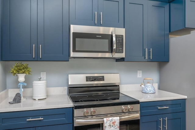 kitchen with stainless steel appliances, blue cabinets, and light countertops