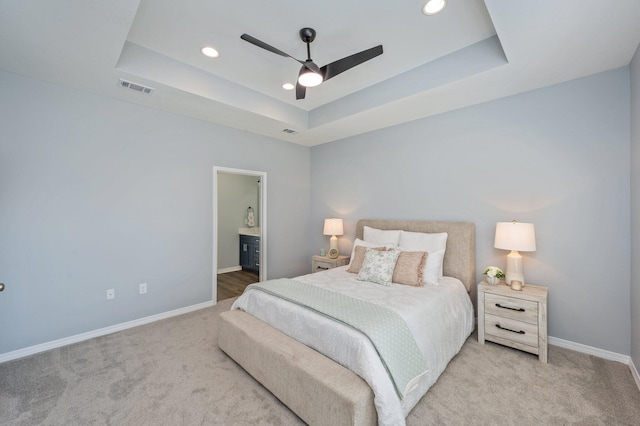 bedroom with carpet, a raised ceiling, baseboards, and visible vents