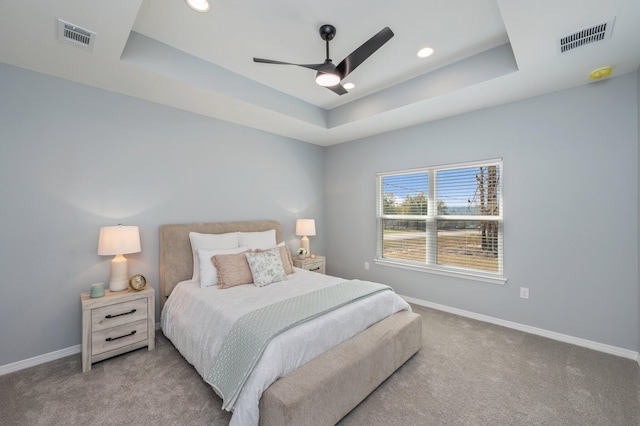 carpeted bedroom with recessed lighting, visible vents, a raised ceiling, and baseboards