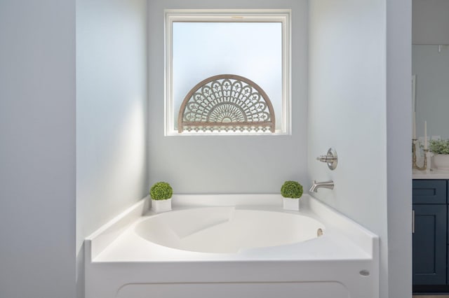 full bathroom featuring a wealth of natural light, a garden tub, and vanity