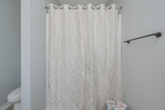 full bathroom featuring curtained shower and toilet