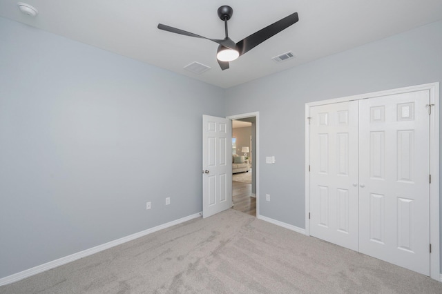 unfurnished bedroom featuring visible vents, a closet, carpet, baseboards, and ceiling fan