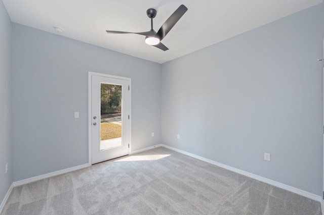 empty room featuring baseboards, light colored carpet, and ceiling fan