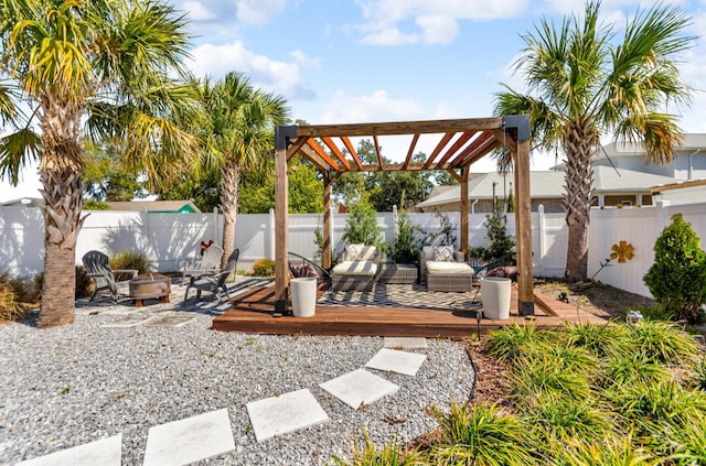 view of yard with a deck, a fenced backyard, a pergola, and a fire pit