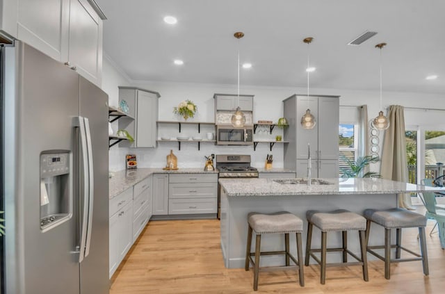 kitchen featuring gray cabinetry, open shelves, decorative backsplash, stainless steel appliances, and a sink