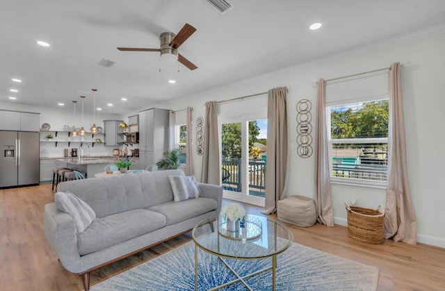 living area with plenty of natural light, recessed lighting, light wood-type flooring, and visible vents