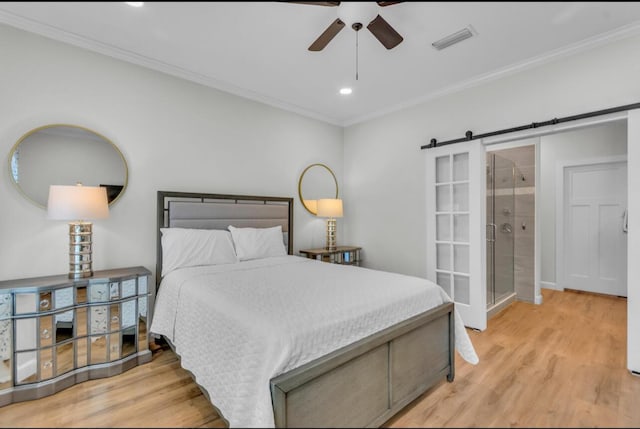 bedroom featuring wood finished floors, visible vents, a barn door, recessed lighting, and crown molding