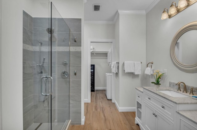 bathroom with visible vents, a shower stall, wood finished floors, and ornamental molding