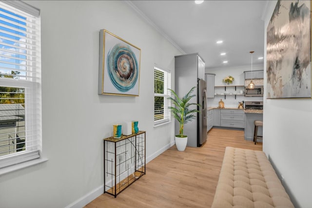 hallway with recessed lighting, baseboards, crown molding, and light wood-style floors