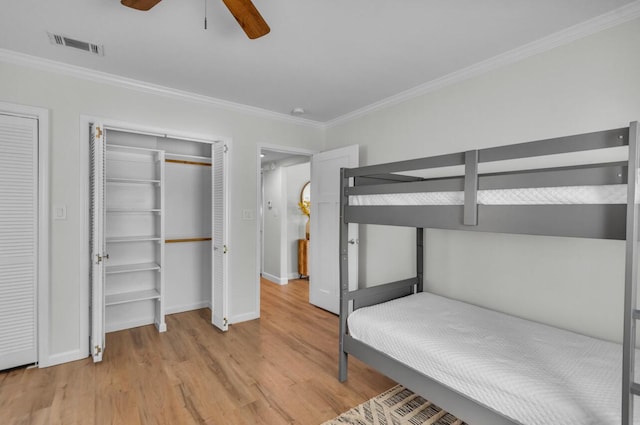 unfurnished bedroom featuring light wood-type flooring, baseboards, visible vents, and ornamental molding