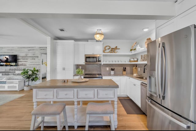 kitchen featuring ornamental molding, a sink, open shelves, stainless steel appliances, and white cabinets