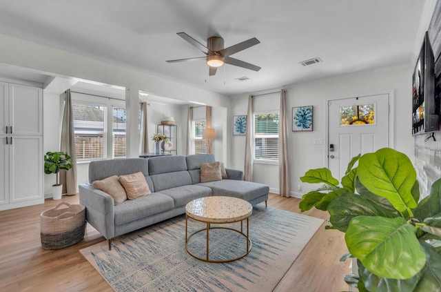 living area featuring light wood finished floors, visible vents, and a ceiling fan