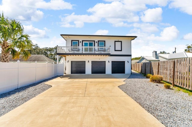 view of front of property with stucco siding, driveway, an attached garage, and fence