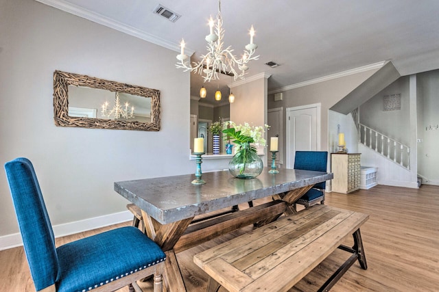 dining space featuring light wood-type flooring, visible vents, baseboards, and stairway