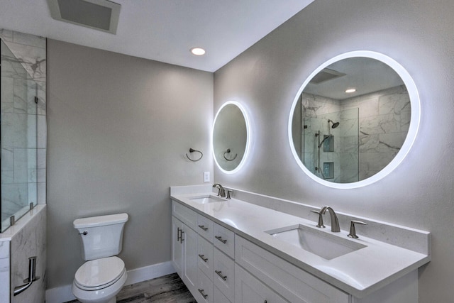 bathroom with a stall shower, toilet, visible vents, and a sink