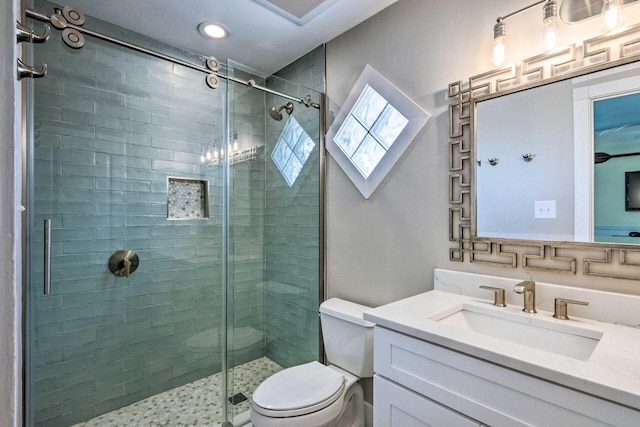 bathroom with visible vents, a shower stall, toilet, and vanity