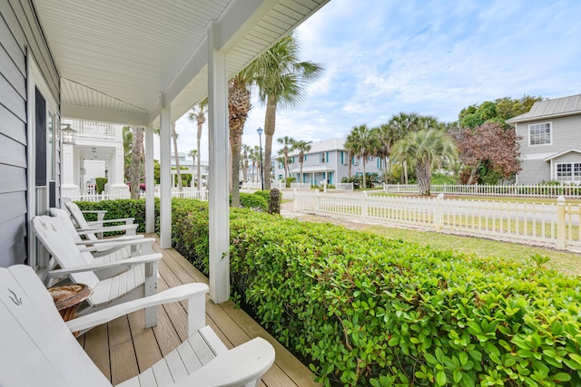 wooden deck with a residential view, covered porch, and fence