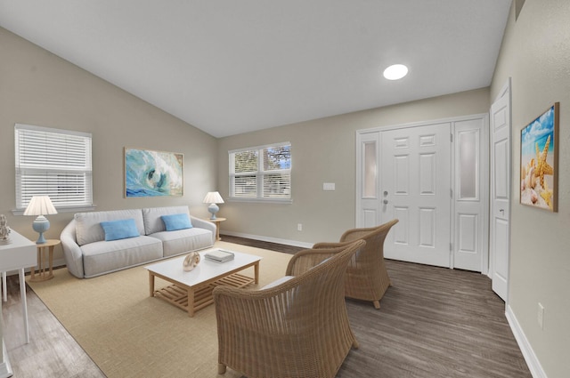 living area with baseboards, lofted ceiling, and wood finished floors