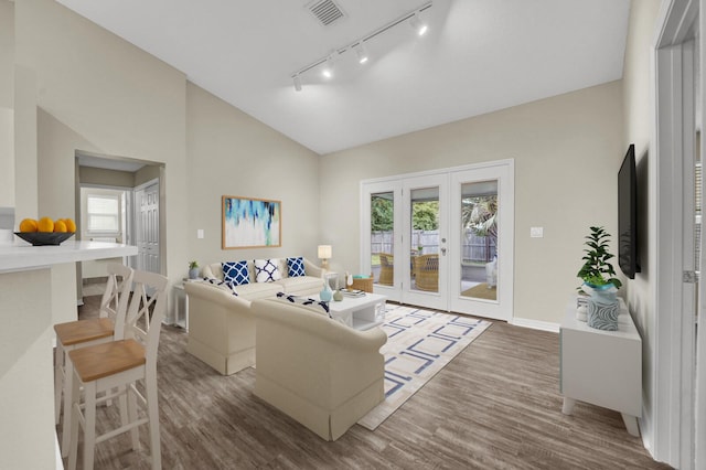 living room featuring visible vents, lofted ceiling, a healthy amount of sunlight, and wood finished floors