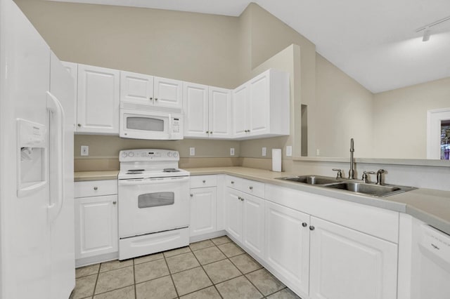 kitchen with light tile patterned flooring, white appliances, white cabinetry, and a sink