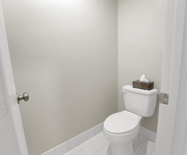 bathroom with tile patterned floors, toilet, and baseboards