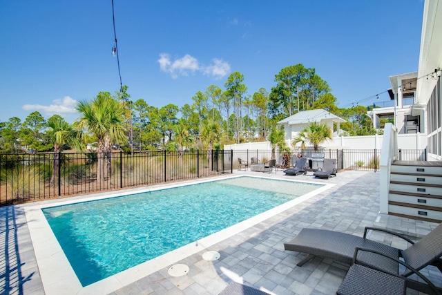 view of swimming pool featuring a patio area, a fenced in pool, and fence