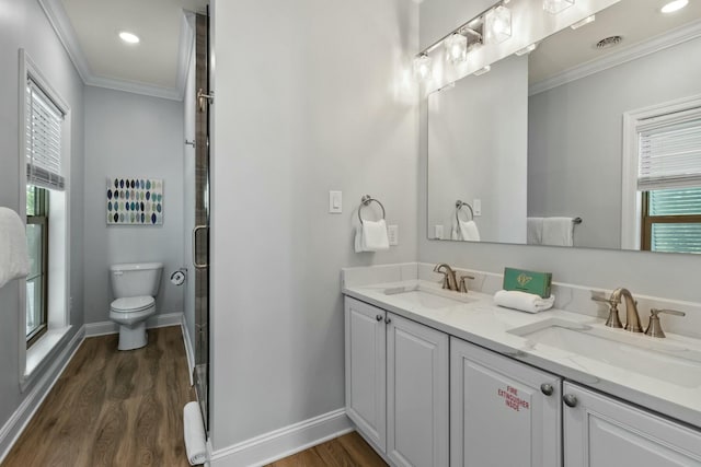 full bath with toilet, wood finished floors, crown molding, and a sink