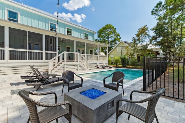 view of swimming pool featuring a fenced in pool, ceiling fan, fence, an outdoor fire pit, and a patio area