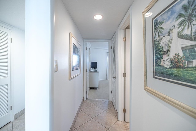 corridor featuring light tile patterned floors, recessed lighting, and baseboards