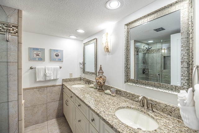 bathroom featuring a shower stall, a textured ceiling, tile walls, and a sink