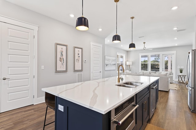 kitchen with recessed lighting, stainless steel appliances, a sink, dark wood-type flooring, and open floor plan