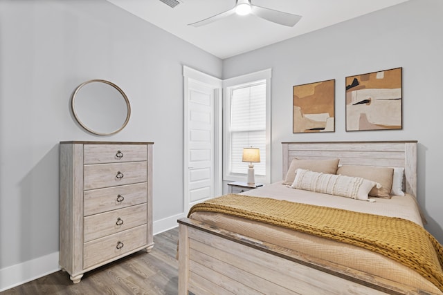 bedroom with dark wood-style floors, ceiling fan, and baseboards