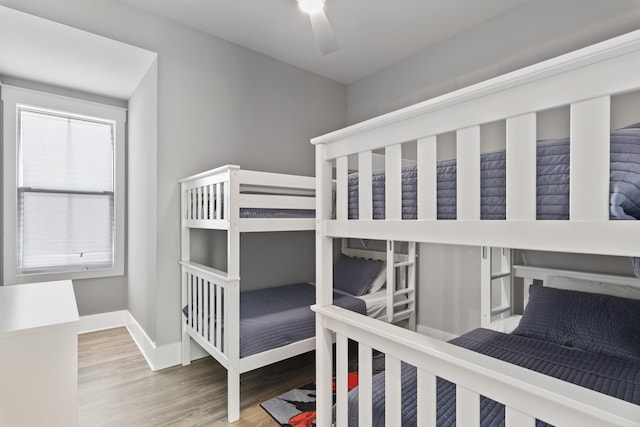 bedroom featuring wood finished floors, baseboards, and ceiling fan