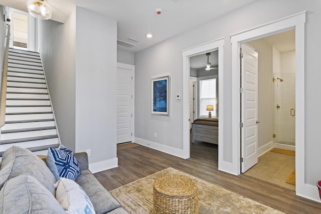 living area with recessed lighting, stairs, baseboards, and wood finished floors