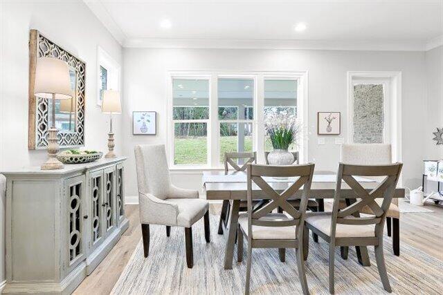 dining space with recessed lighting, light wood-style flooring, and crown molding