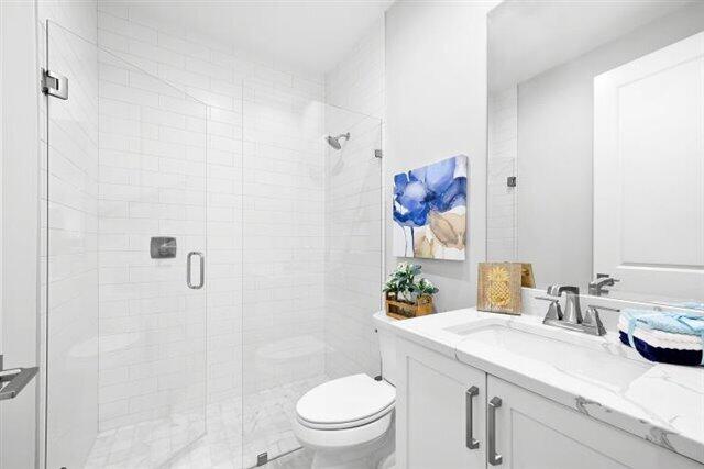 full bath with a shower stall, toilet, and vanity