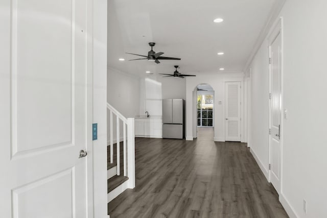 corridor with baseboards, stairs, dark wood-style floors, recessed lighting, and arched walkways