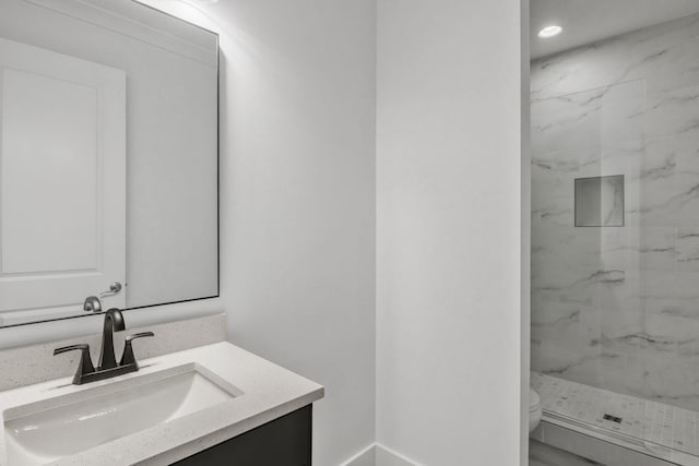 full bathroom featuring a marble finish shower, toilet, and vanity