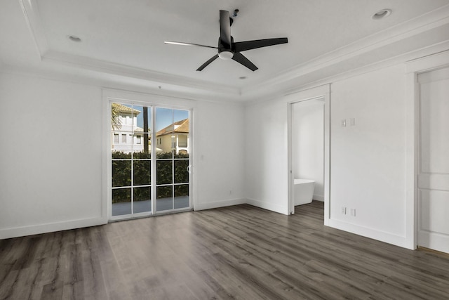 spare room with wood finished floors, a raised ceiling, ornamental molding, and a ceiling fan