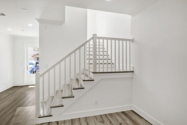 staircase with visible vents, recessed lighting, baseboards, and wood finished floors