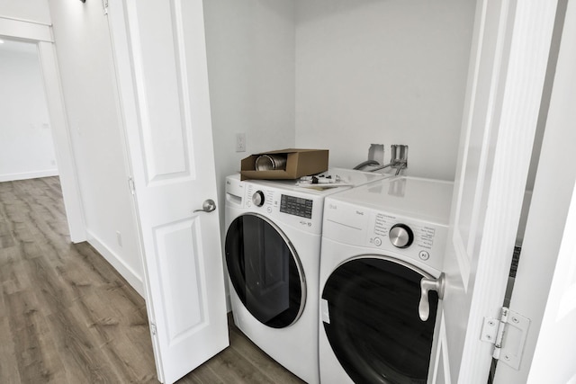 washroom featuring wood finished floors, washing machine and dryer, and laundry area