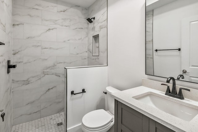 full bath with a marble finish shower, toilet, and vanity