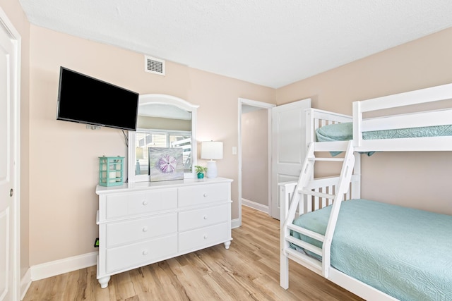 bedroom with visible vents, baseboards, and light wood-style flooring