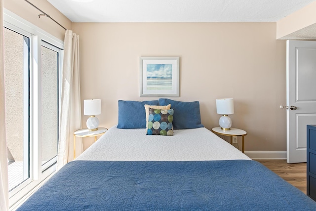 bedroom with wood finished floors and baseboards