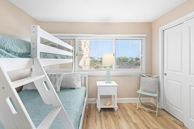 bedroom with baseboards and wood finished floors