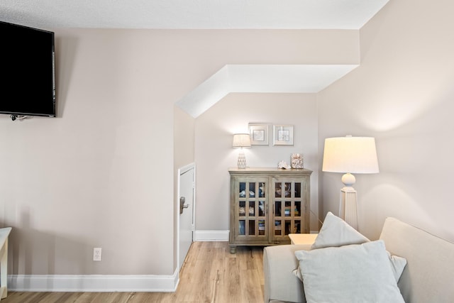 living area with baseboards and wood finished floors