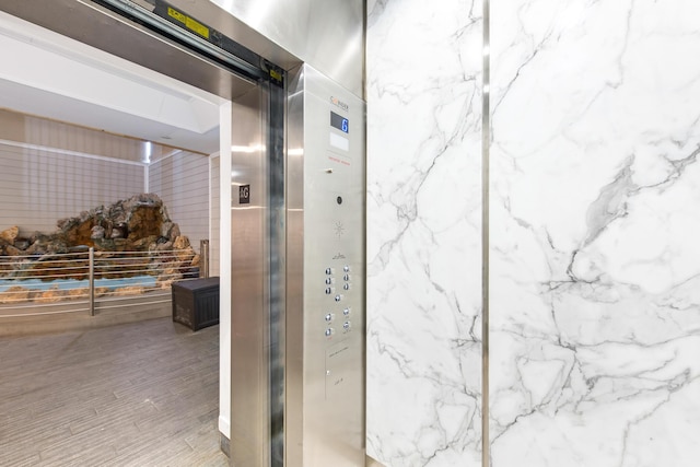 bathroom with elevator and wood finished floors